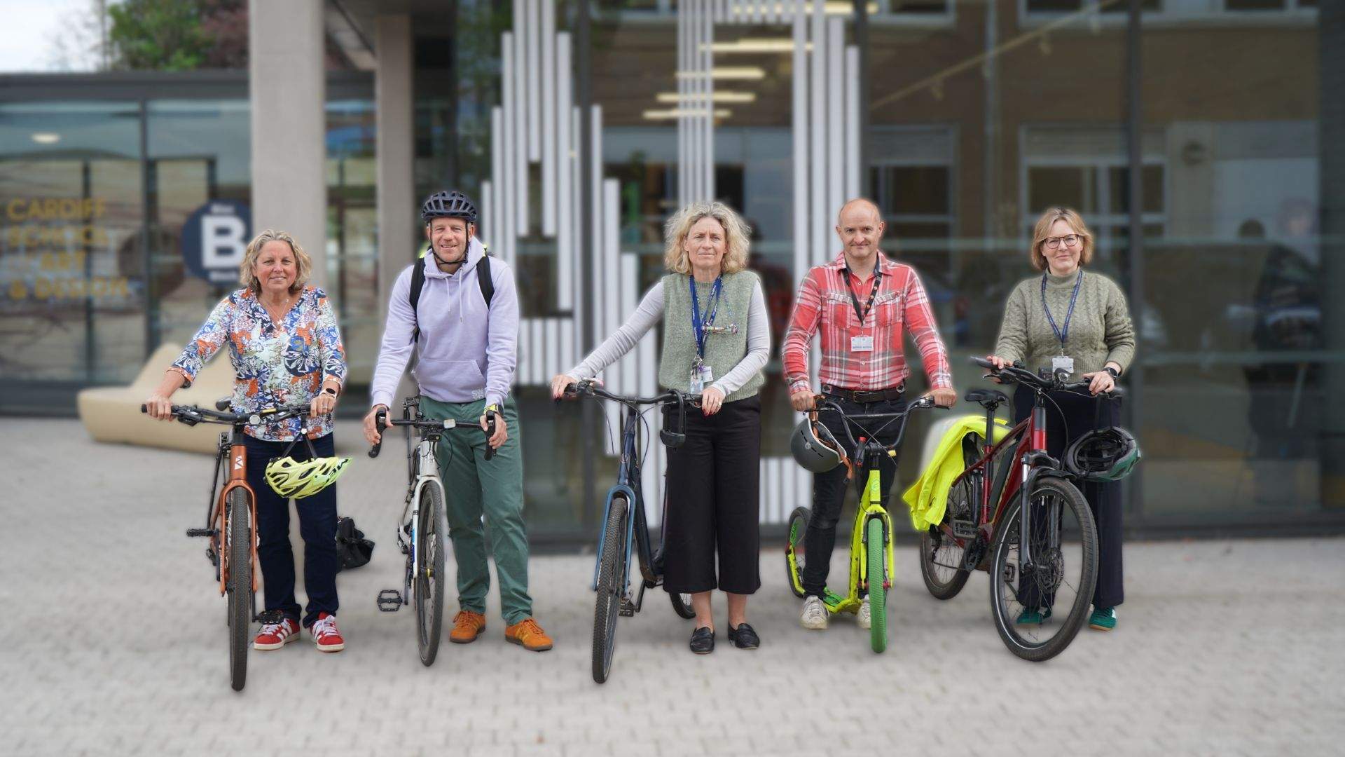 A group of Cardiff Met staff stand with their bicycles