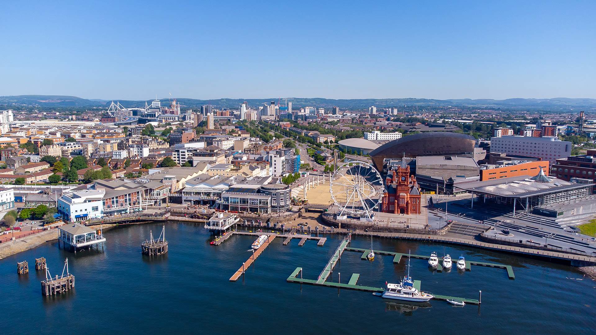 Aerial view of Cardiff city centre with the River Wye flowing through, showcasing urban architecture and green spaces.