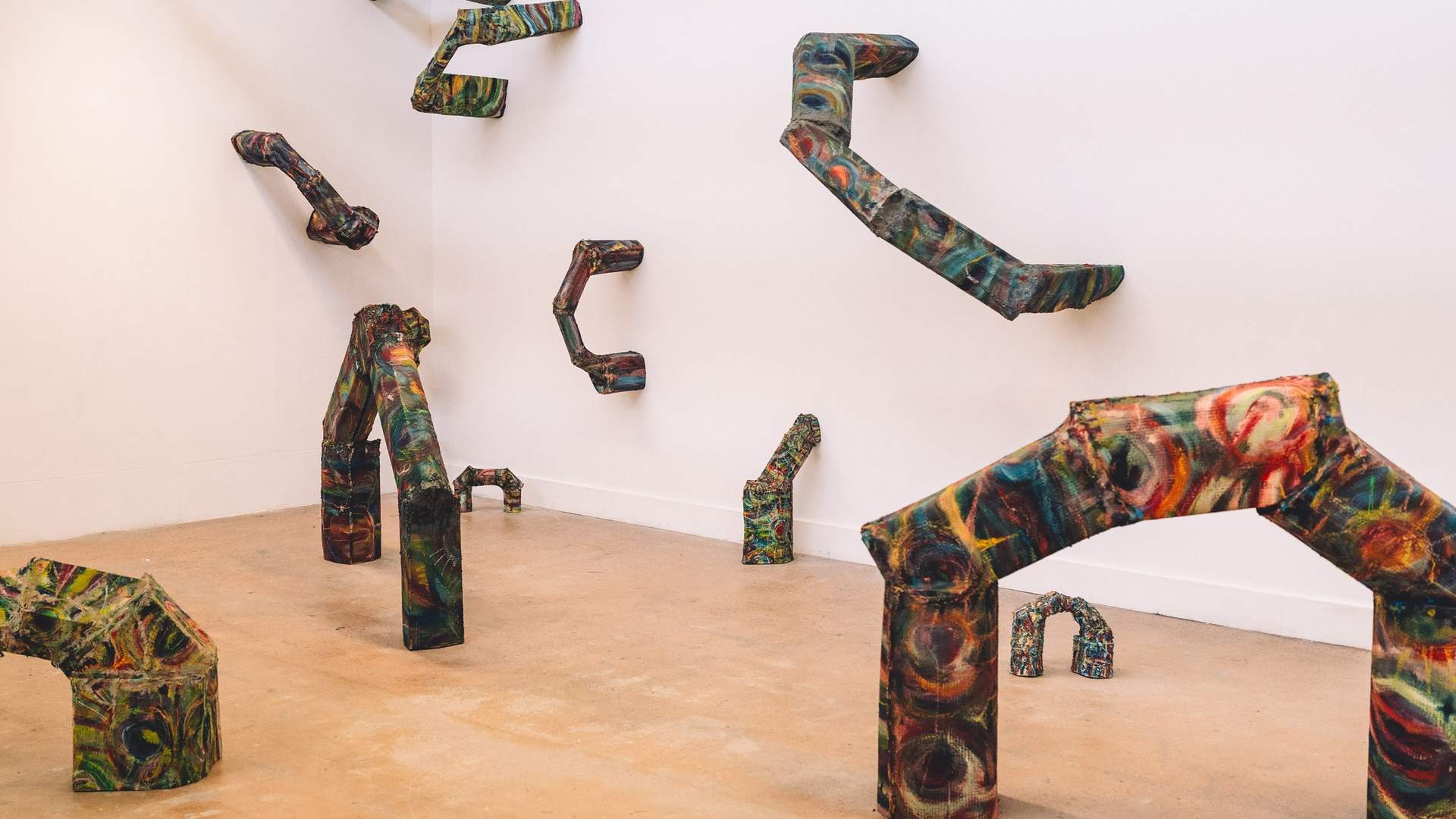 A series of abstract metal art pieces fill an open art space and walls