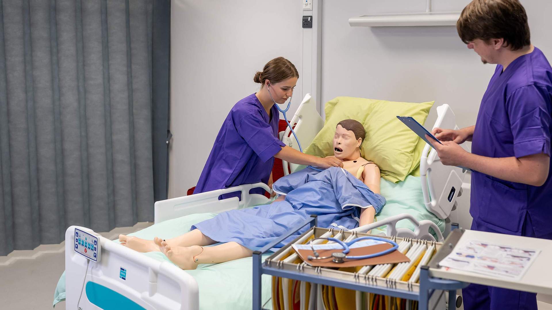 Nursing student places stethoscope on manikin