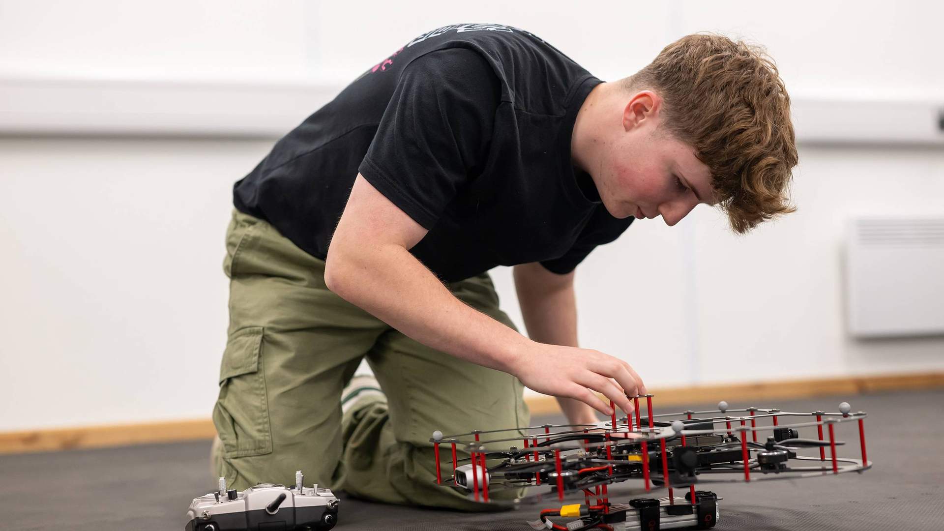 A student works with a small drone quadcopter.