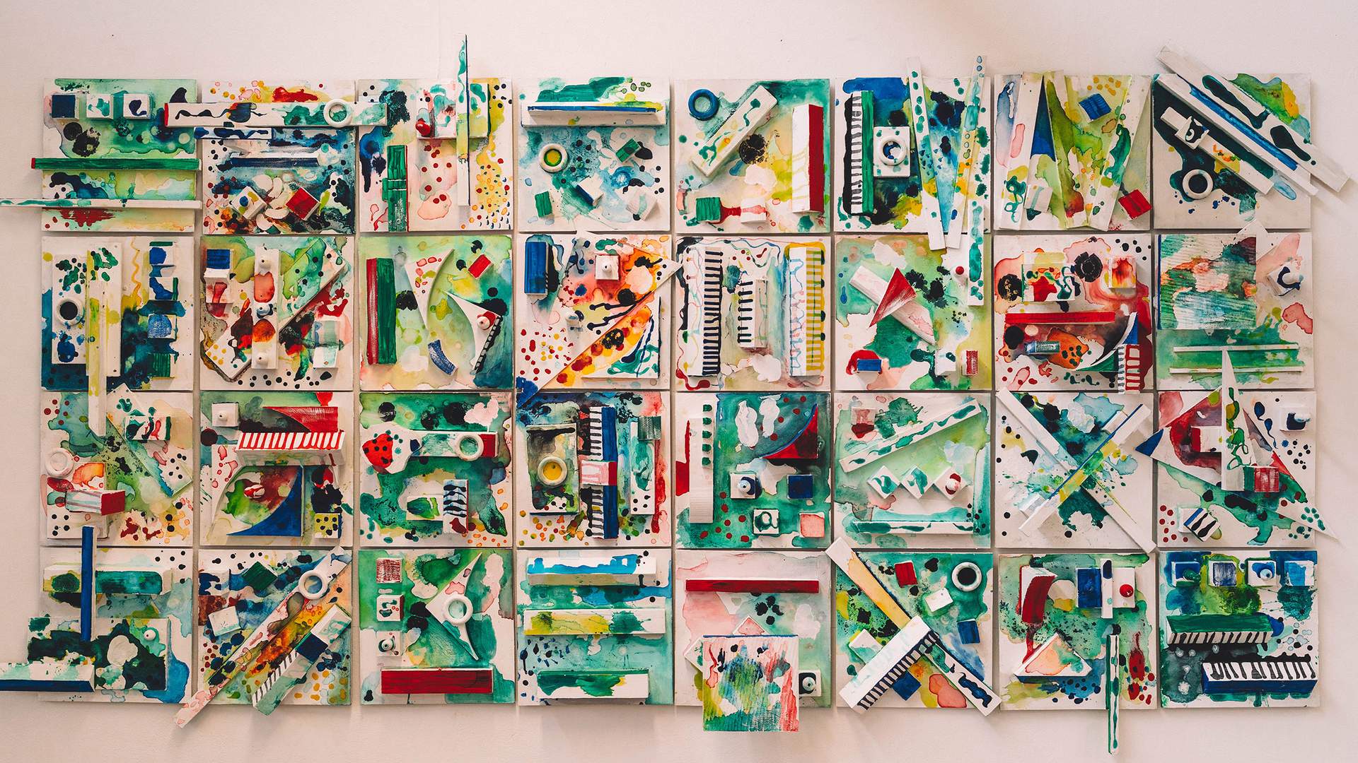 A vibrant wall hanging featuring an array of colorful pieces arranged in an artistic design.