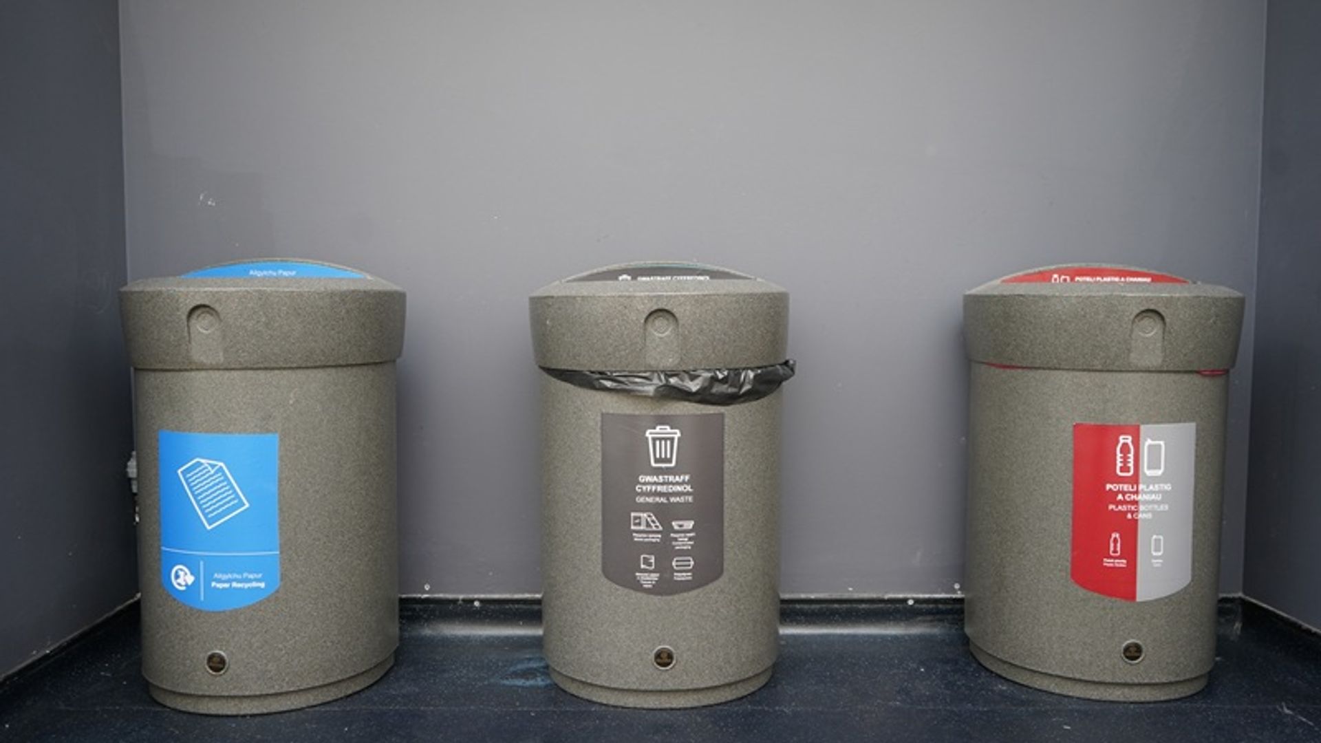 Three colour-coded waste and recycling bins