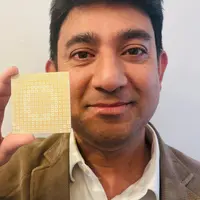 Dr Jasmin Uddin holds a small, flat-panel antenna in their hand