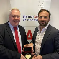 Keith Glanfield receiving a medal from the British Academy of Management