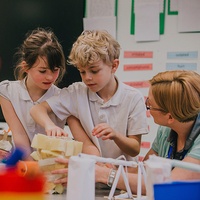 A diverse group of children collaborating on a project, sharing ideas and materials at a table.