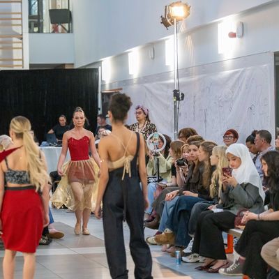 A fashion catwalk in a large open space, surrounded by sitting attendees