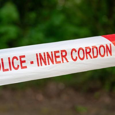 A close-up of police cordon tape. The letters on the tape read POLICE - INNER CORDON.