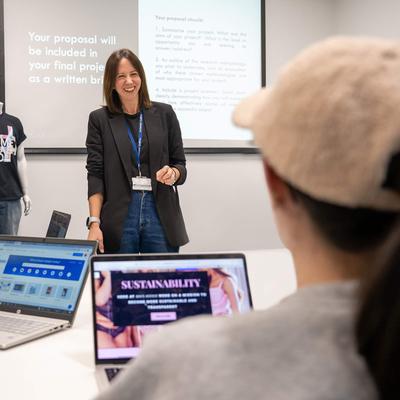 A person stands in front of a class of students.
