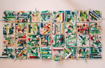 A vibrant wall hanging featuring an array of colourful pieces arranged in an artistic design.