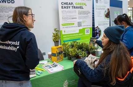 A member of staff talks with a student at a Sustainability information booth