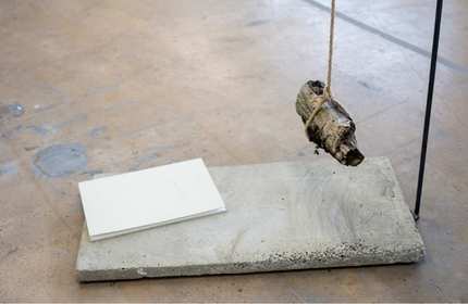 A piece of wood hangs above a slab of concrete