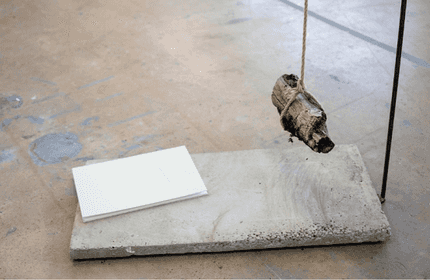A piece of wood hangs above a slab of concrete
