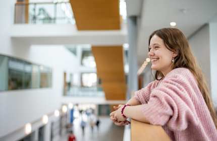 Heather Blackmore leans on the balcony of a mezzanine overlooking the Cardiff School of Management ground floor
