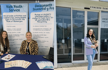 Two women pose in front of a 