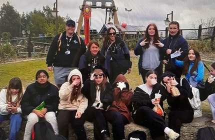 A group of Youth and Community work students, one half sitting and the other half standing, pose for a photograph