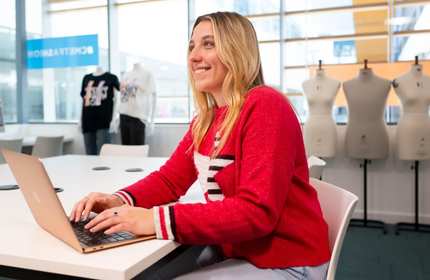 Celyn Williams works from a laptop while sat as a desk