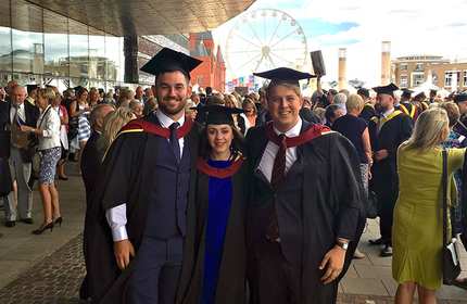 Chelsea Cinquegrani, centre, stands with two other graduates outside the Cardiff Millennium Centre during a busy Graduation day