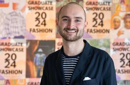 Evan Morgan Williams stands in front of a wall of posters