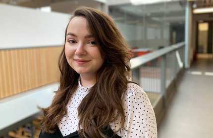 Headshot of Katie Price, as they stand on an elevated walkway