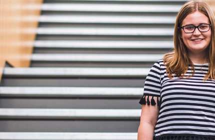 Cathrin Jones stands in front of a set of stairs