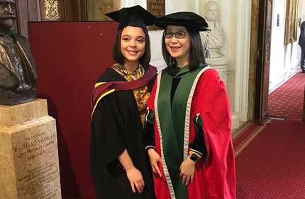 Christie Smith stands for a photograph with the Dean of School of Management