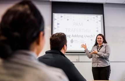Hanna Turner giving a presentation in front of a projector display