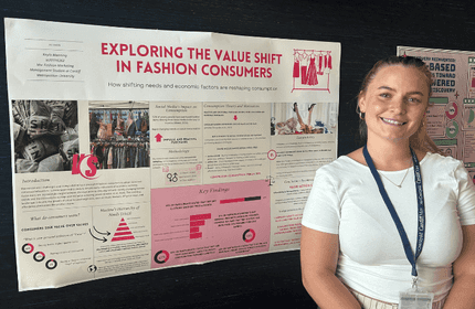 A young woman in a white t-shirt stands in front of an information display