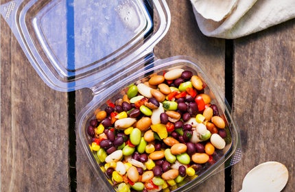 A plastic food container containing a colourful bean salad
