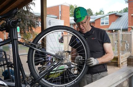 A man inspects a bicycle on a raised platform