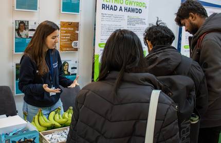 A member of the Sustainability team engages in conversation with students at a Go Green Week information stall