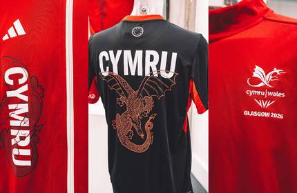 Wales Commonwealth team kit featuring a red jersey with white accents and the Welsh dragon emblem on the chest.