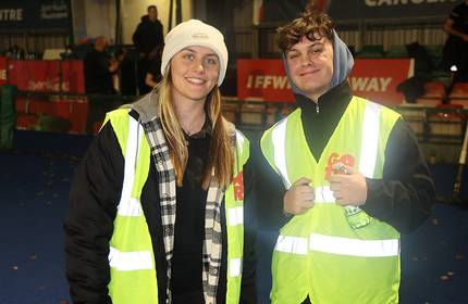 Jack Morgan stands with a woman, both of whom are wearing high-visibility jackets