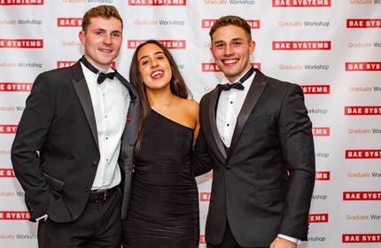 Kieran Bevan and two others wearing black tie event clothing stand for a photograph