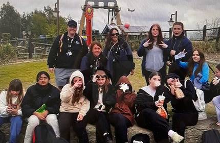 A group of Youth and Community work students, one half sitting and the other half standing, pose for a photograph