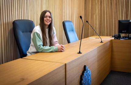 A person seated at a courtroom desk.