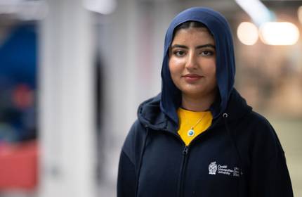 A young woman in a headscarf wearing a Cardiff Met hoodie.