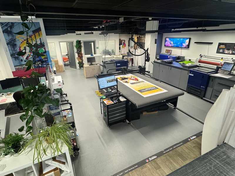 A view from the corner of the Print Studio, featuring various printing machines and workbenches