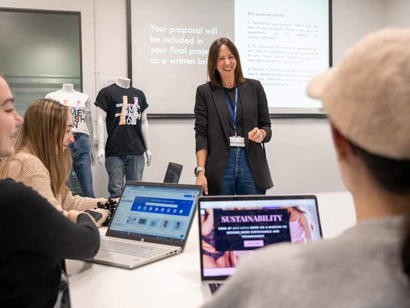 A person stands in front of a class of students.