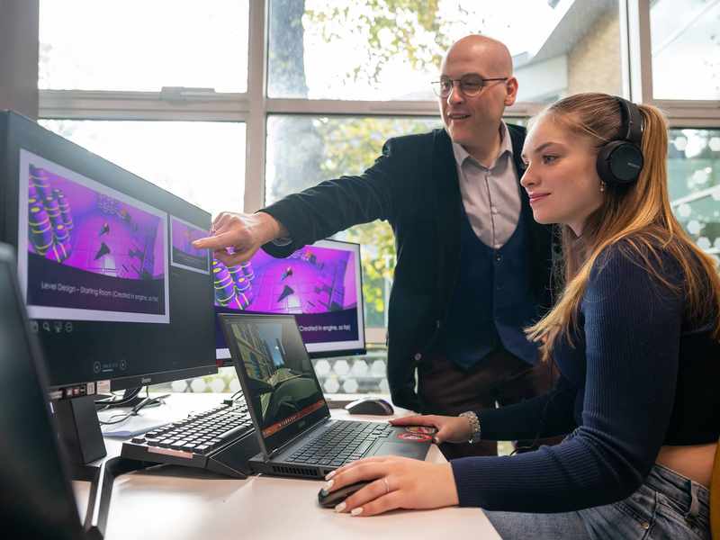 Lecturer and student using computer workstation