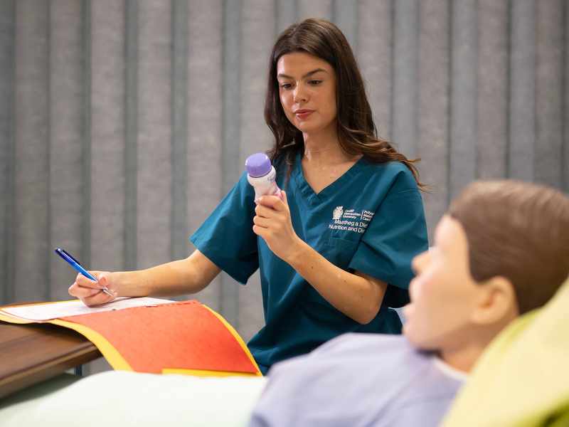 Nutrition and Dietetics student with manikin in Allied Clinical Health Hub Simulation Suite