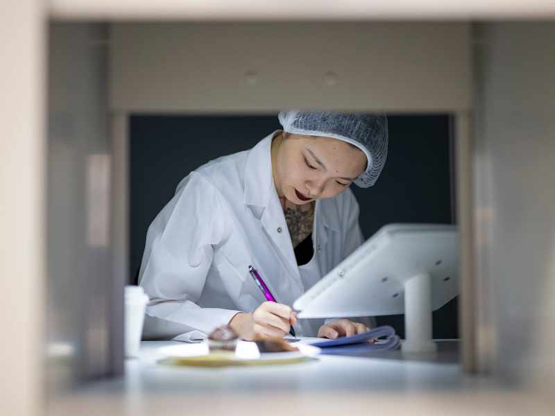 Student writing notes in Food Industry Centre evaluation suite