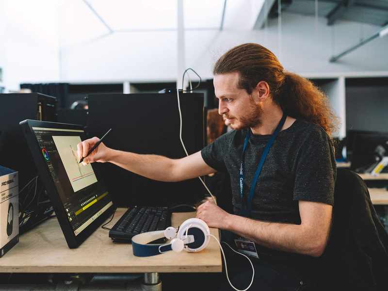 A student draws on a pen display using a stylus.