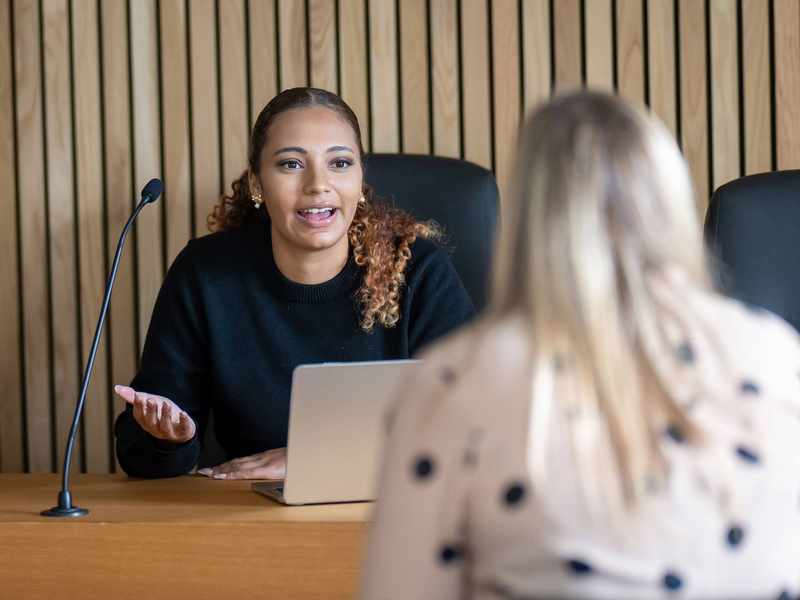 Student sitting at bench in Moot Courtroom