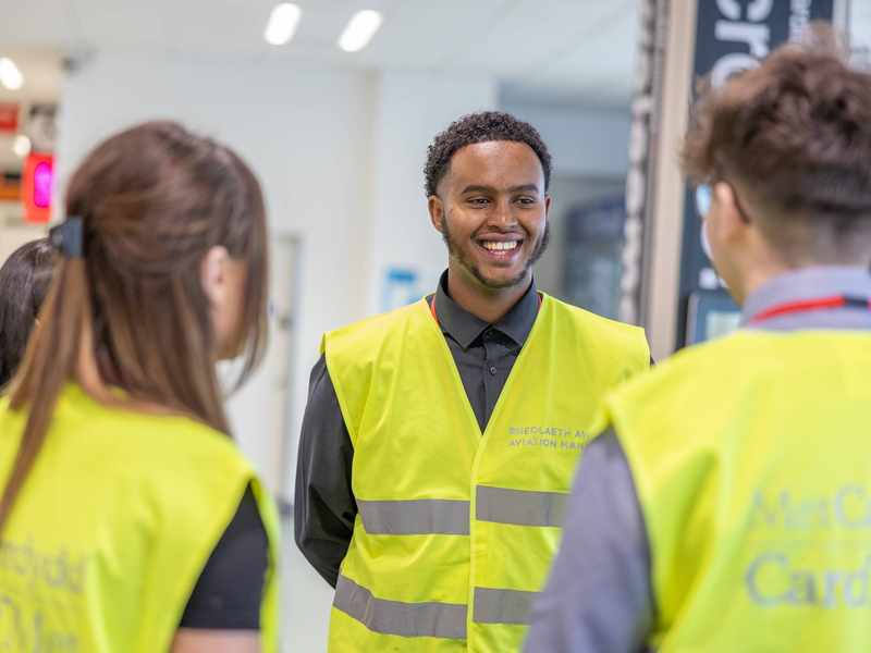 A group of three people standing together in an airport terminal.