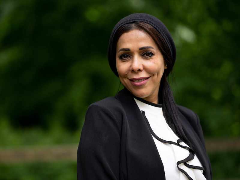 A person wearing a headscarf and dark jacket