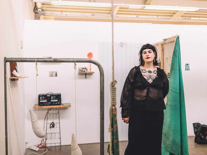 A person stands in front of an art installation.