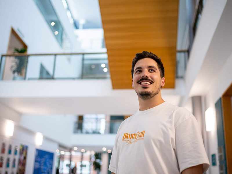 A person stands in a brightly lit atrium space.