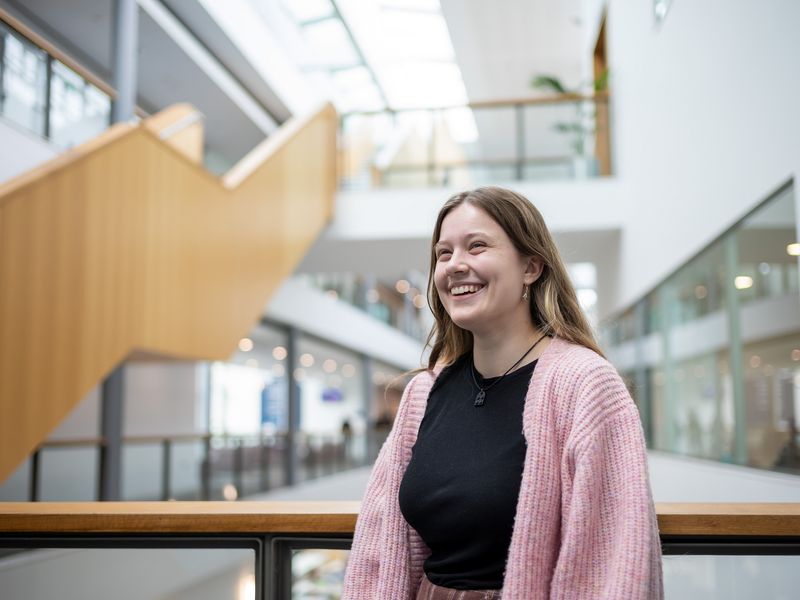 Heather Blackmore leans on the balcony of a mezzanine overlooking the Cardiff School of Management ground floor