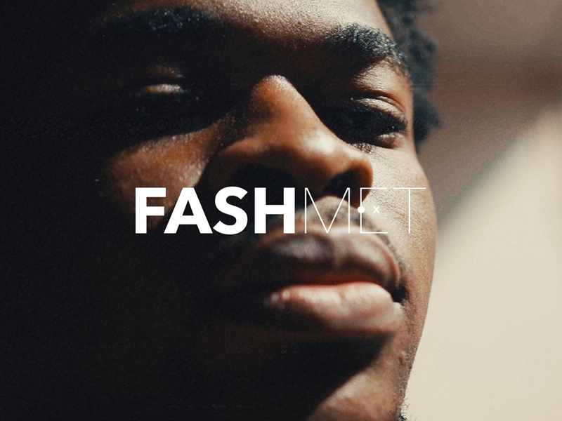 A young man looks into the camera with the text 'FashMet' in front of his face